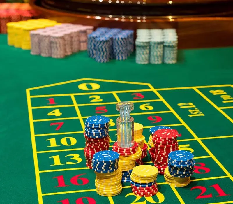 Atmospheric gaming hall featuring a woman in a red gown at the roulette wheel — the hallmark of CrownBD luxury.